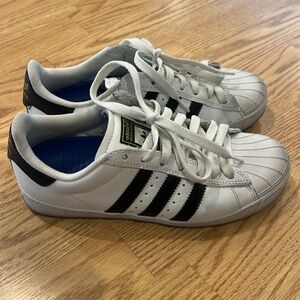 Adidas white and black shell toe sneakers with gold logo